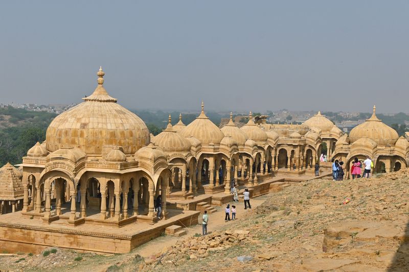 Sandstone chhatris, cenotaphs adorned with domes and spires in the desert landscape of Jaisalmer Rajasthan, blog by The Kid Who Travelled.