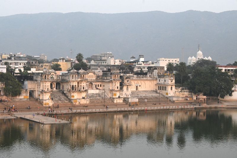 Reflection of the ghats and temples on the calm waters of Pushkar Lake at sunrise, Pushkar blog by The Kid Who Travelled